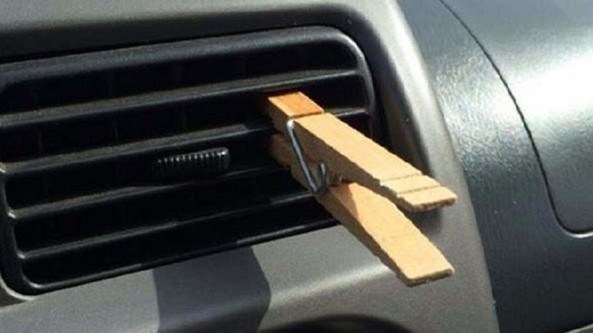 Pinza de madera en el aire acondicionado del coche